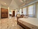 Spacious bedroom with marble flooring and ample natural light