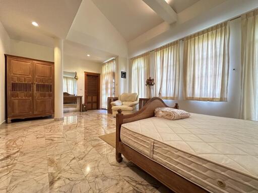 Spacious bedroom with marble flooring and ample natural light
