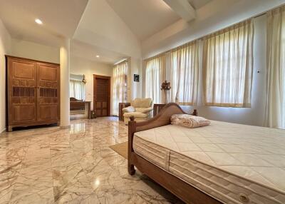 Spacious bedroom with marble flooring and ample natural light
