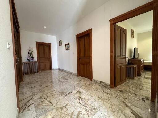 Spacious hallway with marble flooring and wooden doors