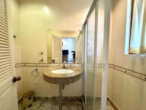 Modern bathroom with glass shower and marble flooring