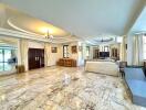Spacious living room with marble flooring and ample natural light