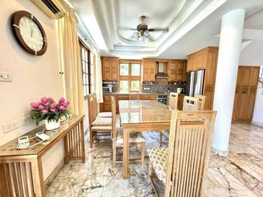 Spacious kitchen with dining area, wooden cabinets, and marble flooring