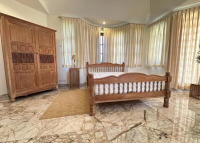 Spacious bedroom with large wooden armoire and marble flooring