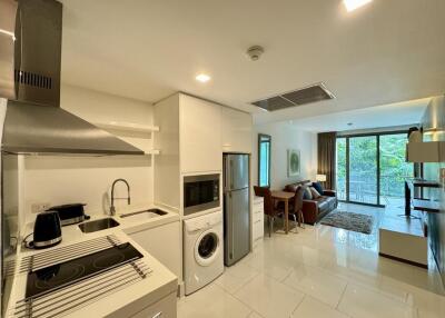 Modern kitchen with stainless steel appliances and open floor plan leading to living area