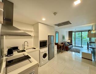 Modern kitchen with stainless steel appliances and open floor plan leading to living area