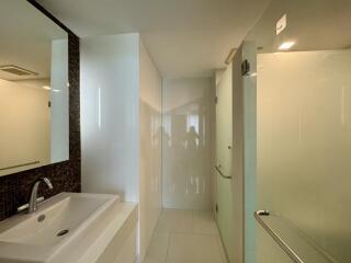 Modern bathroom interior with glass shower and white basin