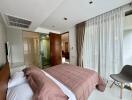 Comfortable bedroom with large bed, en-suite bathroom and floor-to-ceiling windows