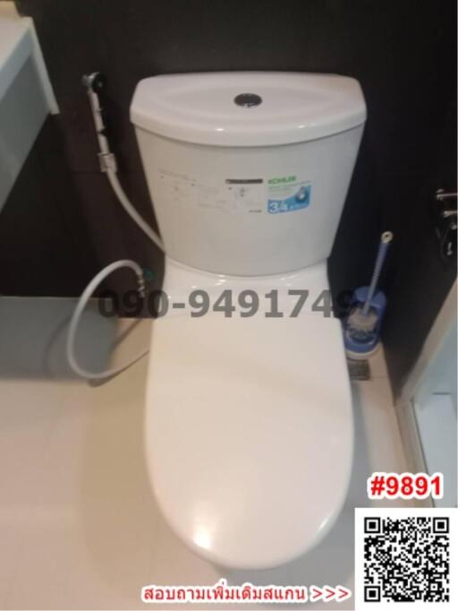 Modern white ceramic toilet in a bathroom with a visible toilet brush