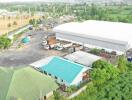 Aerial view of industrial property with large warehouse and surrounding greenery
