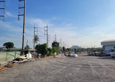 Vast outdoor space with power lines and industrial buildings under a clear sky