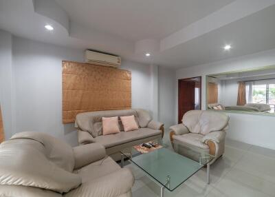 Spacious and well-lit living room with modern furniture and air conditioning