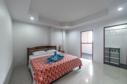 Spacious and well-lit bedroom with a queen-sized bed and modern amenities