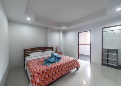 Spacious and well-lit bedroom with a queen-sized bed and modern amenities