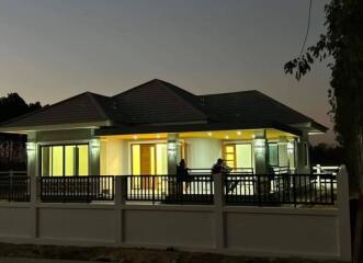 Modern house exterior at dusk with illuminated windows