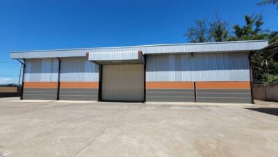 Exterior view of a modern industrial warehouse with a large sliding door