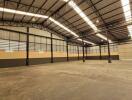 Spacious industrial warehouse interior with high ceiling and lighting