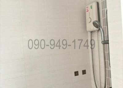 Modern white tiled bathroom with shower appliance