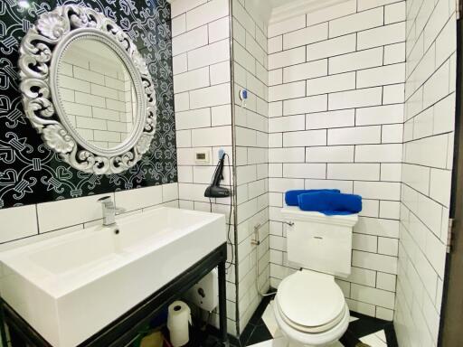 Contemporary bathroom with black and white tiles and ornate mirror