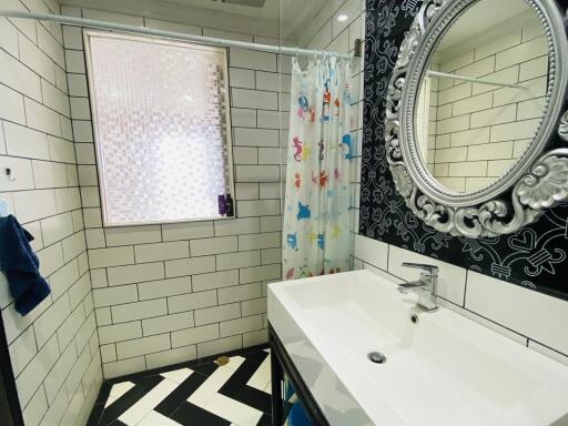Modern bathroom with black and white tiles and decorative mirror