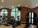 Modern gym with cardio equipment and brick walls