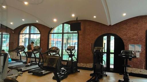 Modern gym with cardio equipment and brick walls