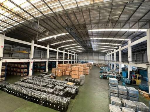 Spacious industrial warehouse interior with goods and pallet storage