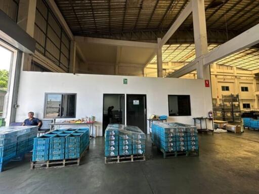 Spacious warehouse interior with pallets and office space