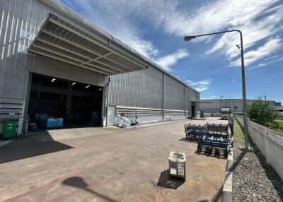 Industrial warehouse exterior with open entrance and outdoor seating area