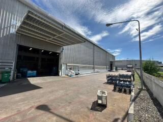 Industrial warehouse exterior with open entrance and outdoor seating area