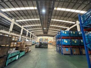 Spacious industrial warehouse interior with stacked goods and storage racks