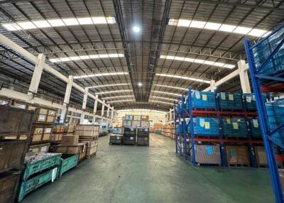 Spacious industrial warehouse interior with stacked goods and storage racks