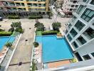 Aerial view of a residential complex with pool and parking area