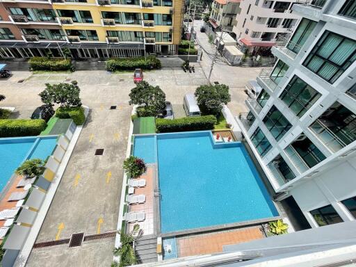 Aerial view of a residential complex with pool and parking area