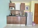 Compact modern kitchen with stainless steel appliances and wooden cabinetry