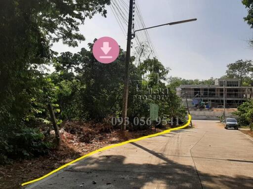 Outdoor view of a property under construction with surrounding nature and street access