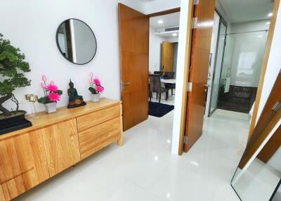 Modern hallway interior with wooden console, decorative mirror, and bonsai tree