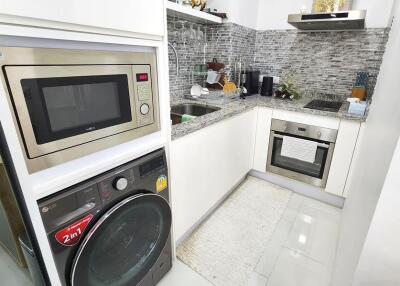 Modern kitchen with stainless steel appliances and gray tiled backsplash