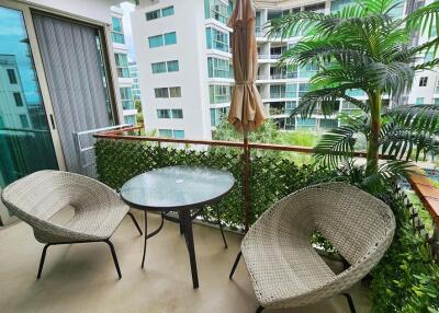 Cozy furnished balcony with greenery and a view of adjacent buildings