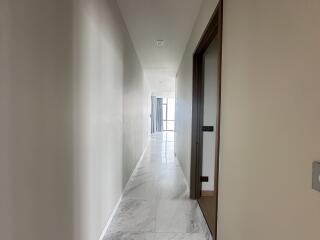 Bright and spacious hallway leading to rooms with marble flooring