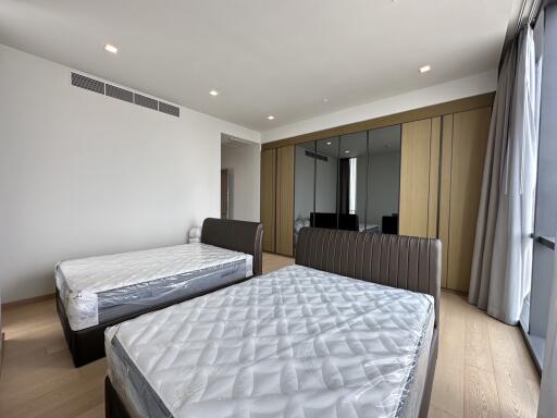 Spacious modern bedroom with a large mirror and two beds