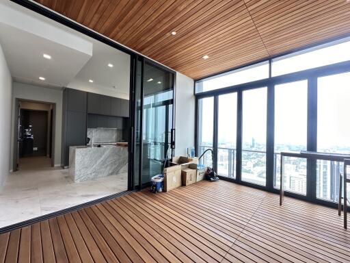 Spacious balcony with wooden flooring and glass barrier offering city views