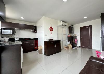 Spacious modern kitchen with integrated appliances and tiled flooring