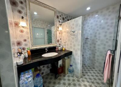 Spacious bathroom with patterned tiles, modern vanity, and glass shower