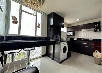 Modern kitchen with black countertops and ample natural light