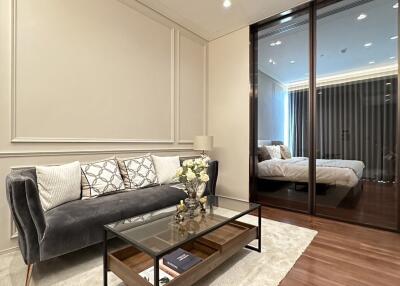 Elegant living room with hardwood floors and a mirrored wall reflecting the interior