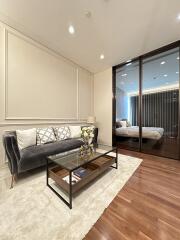 Elegant living room with hardwood floors and a mirrored wall reflecting the interior