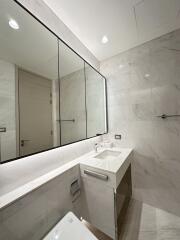 Modern bathroom with marble tiles and large mirror