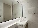 Modern bathroom with marble tiles and large mirror