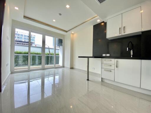 Modern kitchen with white cabinets, black backsplash, and natural light